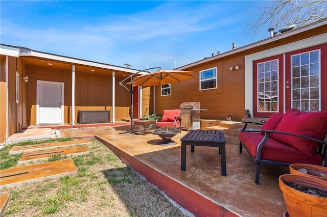 view of patio with an outdoor living space with a fire pit