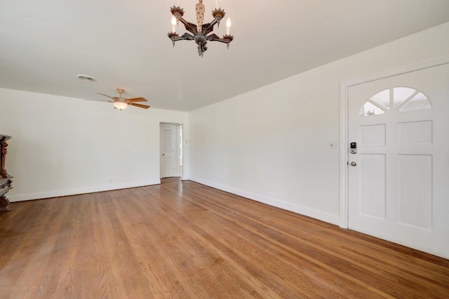 entrance foyer featuring ceiling fan with notable chandelier and light hardwood / wood-style floors