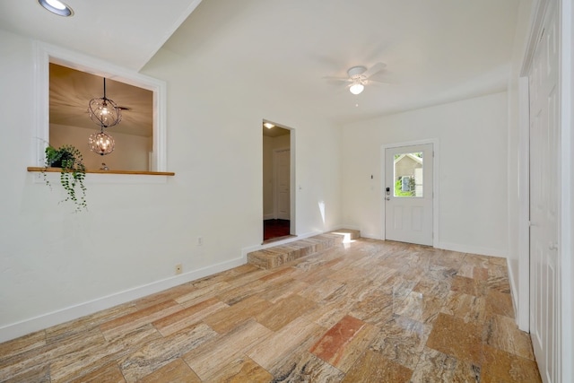 foyer entrance with ceiling fan with notable chandelier