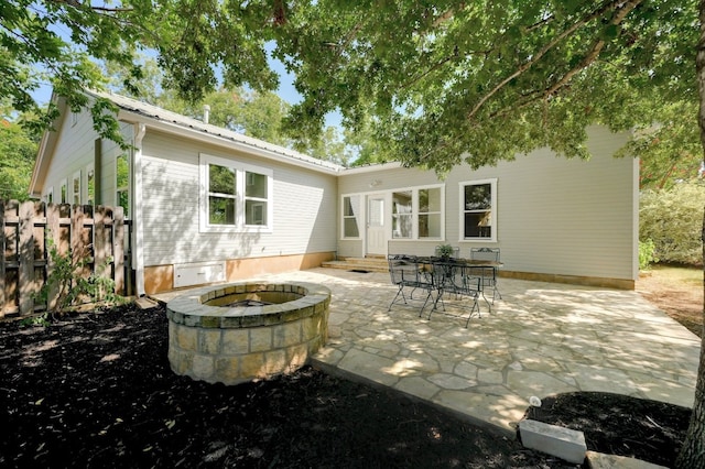 rear view of property featuring an outdoor fire pit and a patio