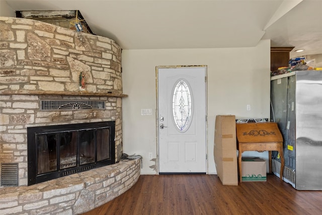 foyer entrance featuring dark wood-type flooring and a fireplace