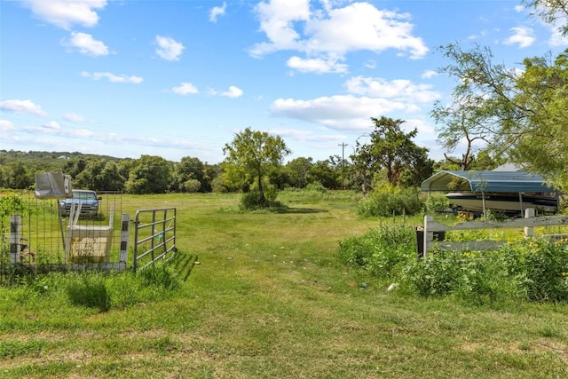 222 Pope Bnd N, Cedar Creek, TX 78612 - view of green lawn featuring a detached carport, a rural view, and a gate