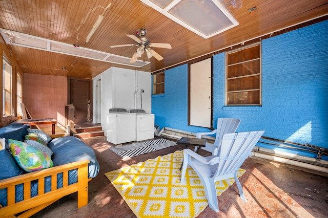 bedroom featuring brick wall, wood ceiling, washer and clothes dryer, and concrete floors