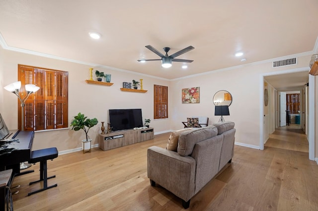 living room with crown molding, ceiling fan, and light wood-type flooring