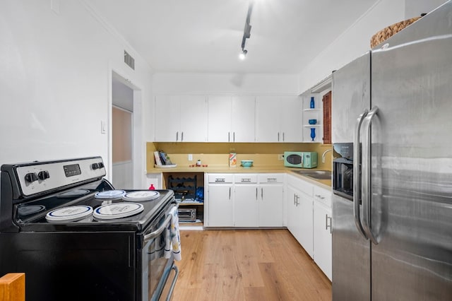 kitchen with sink, stainless steel appliances, track lighting, light hardwood / wood-style floors, and white cabinets