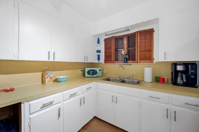 kitchen with white cabinetry, beverage cooler, and sink