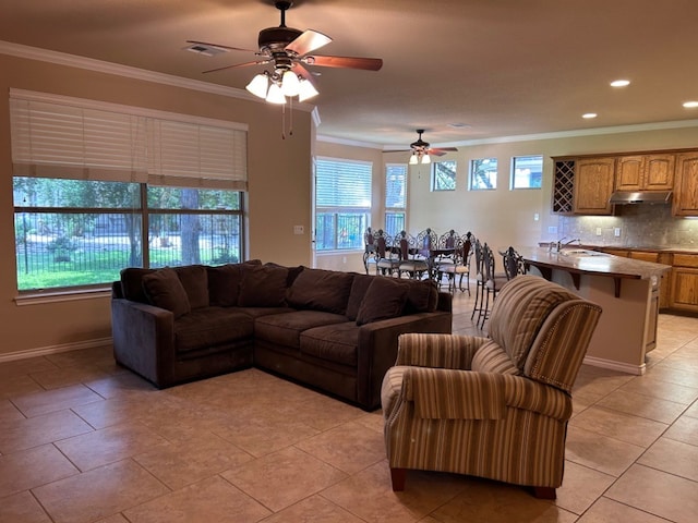 living room featuring sink, ceiling fan, crown molding, and light tile patterned flooring