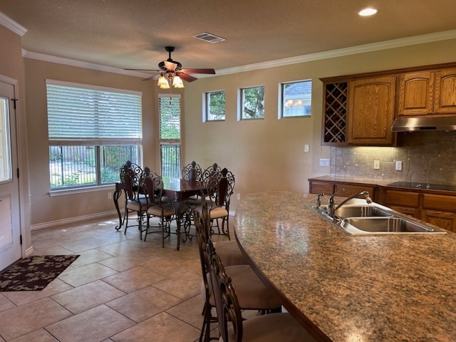 kitchen with backsplash, crown molding, sink, ceiling fan, and black electric cooktop