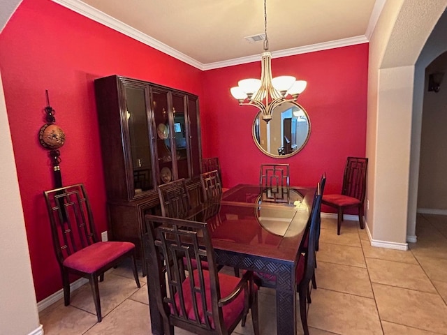 tiled dining area featuring a notable chandelier and ornamental molding