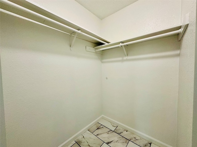 walk in closet with tile flooring