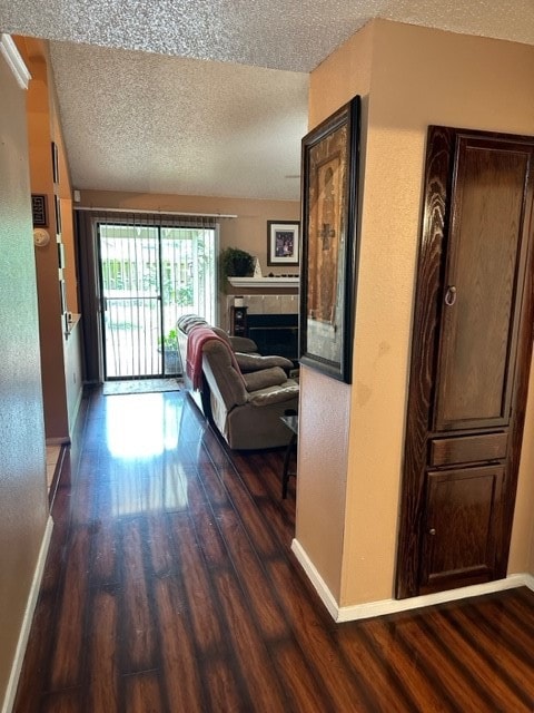 hallway with dark wood-type flooring and a textured ceiling