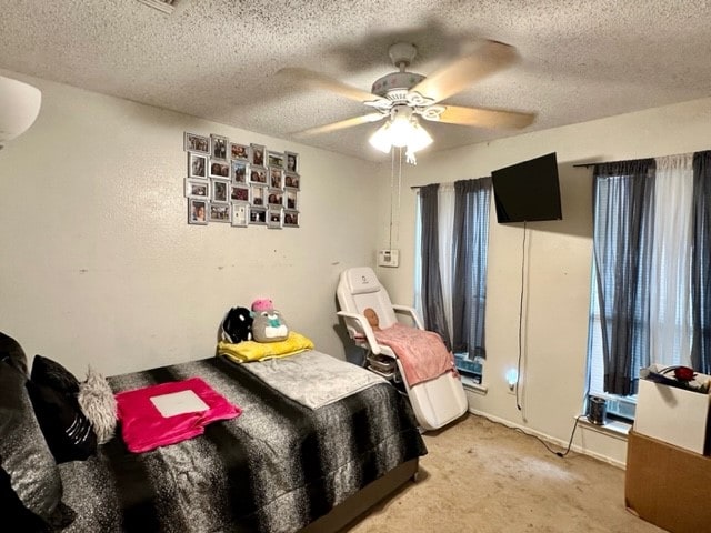 bedroom with ceiling fan, a textured ceiling, and light carpet