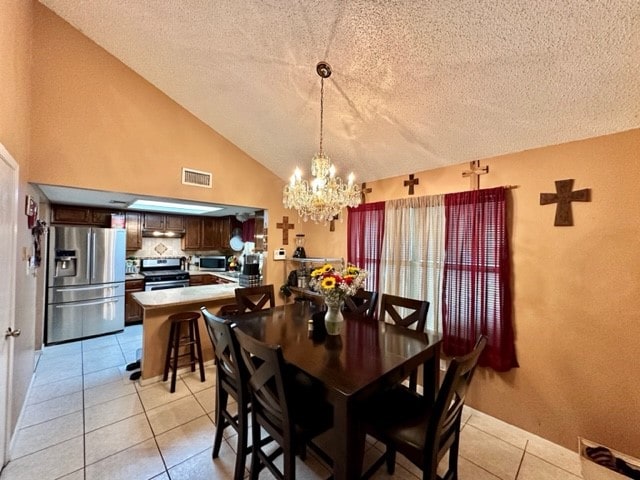 dining space featuring a textured ceiling, high vaulted ceiling, a notable chandelier, and light tile patterned floors