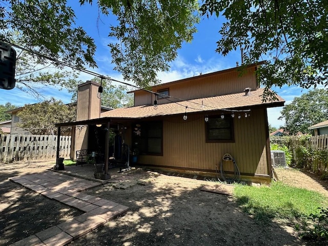 5509 Teri Rd, Austin, TX 78744 - back of house featuring a patio area, a fenced backyard, a chimney, central AC, and a shingled roof
