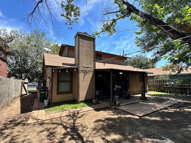5509 Teri Rd, Austin, TX 78744 - back of house featuring fence, a chimney, and a patio