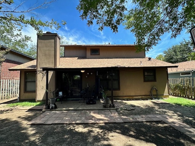 5509 Teri Rd, Austin, TX 78744 - back of property featuring a chimney, fence, a patio, and a shingled roof