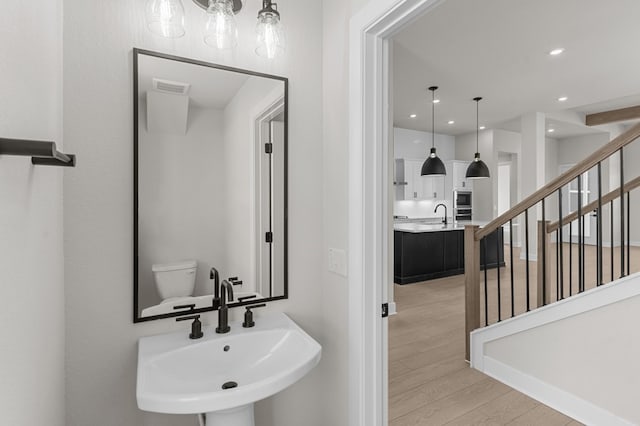 bathroom featuring hardwood / wood-style flooring, sink, and toilet