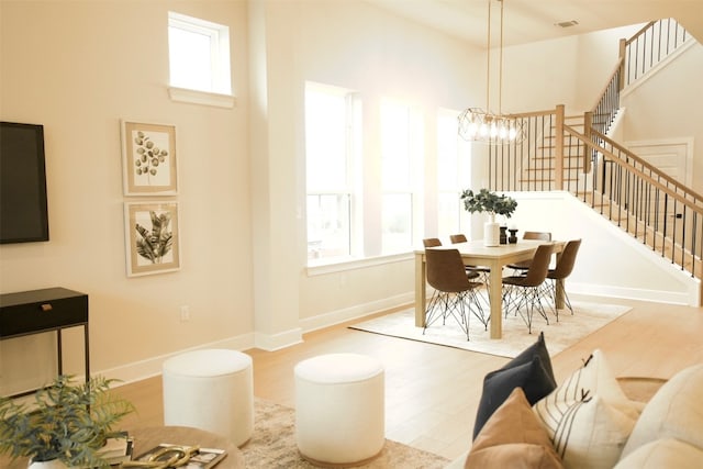 dining area with a healthy amount of sunlight, an inviting chandelier, and light hardwood / wood-style floors