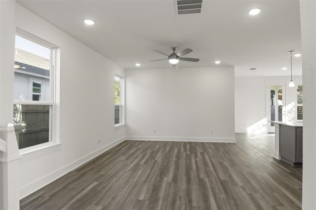 unfurnished living room featuring ceiling fan and dark wood-type flooring