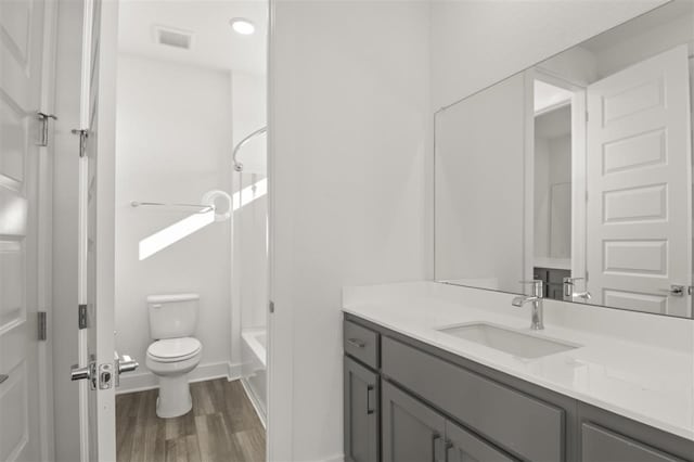 full bathroom featuring shower / bath combination, hardwood / wood-style flooring, vanity, and toilet