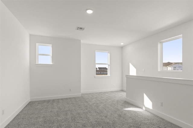 carpeted spare room featuring a healthy amount of sunlight