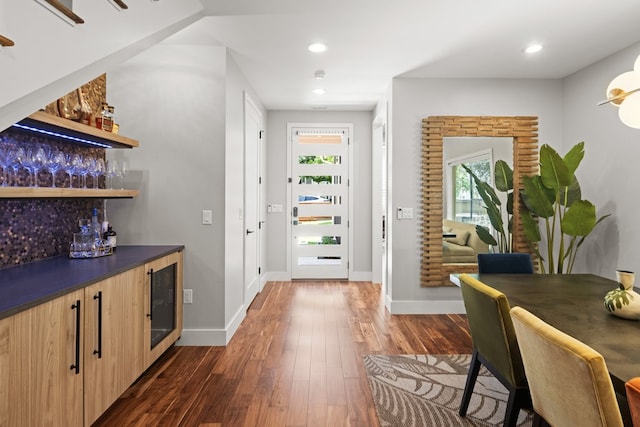 interior space with beverage cooler, bar area, and dark hardwood / wood-style flooring