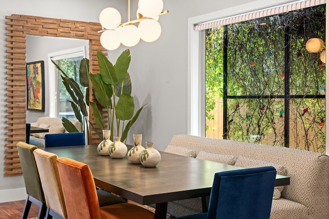 dining area with hardwood / wood-style floors and an inviting chandelier