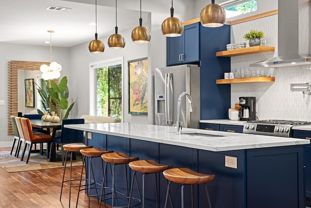 kitchen featuring light stone countertops, blue cabinetry, dark wood-type flooring, extractor fan, and appliances with stainless steel finishes