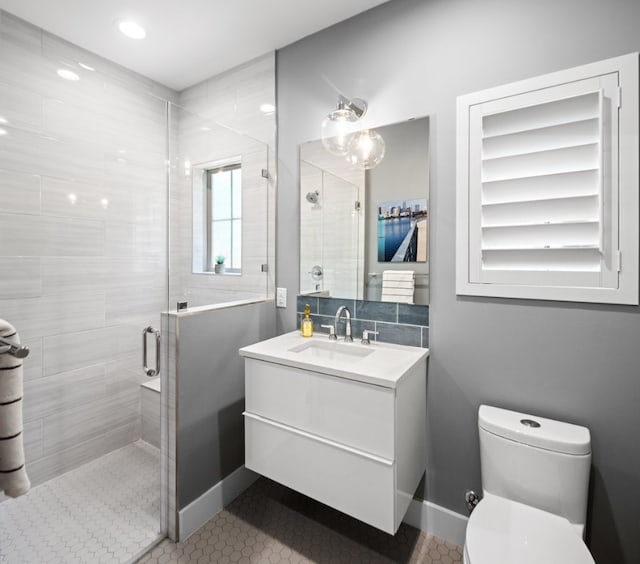 bathroom with walk in shower, vanity, tile patterned flooring, and toilet