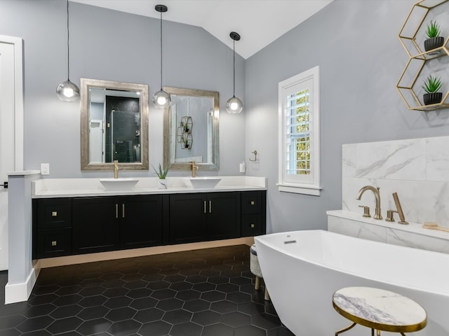 bathroom with lofted ceiling, a bath, tile patterned flooring, and vanity