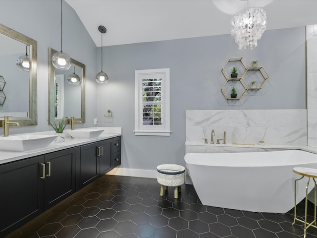 bathroom featuring vanity, lofted ceiling, a bathtub, and tile patterned floors