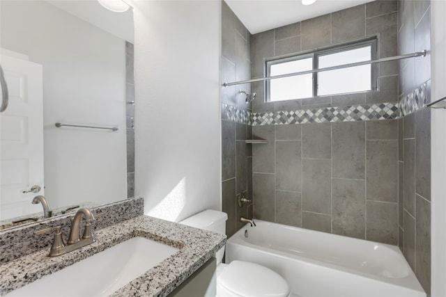 full bathroom with tiled shower / bath, vanity, and toilet