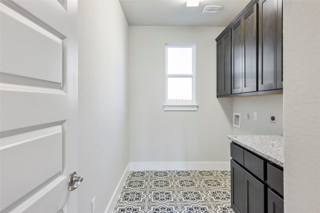 washroom featuring cabinets, hookup for an electric dryer, light tile floors, and washer hookup