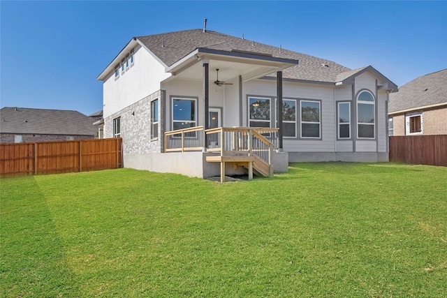 rear view of house with a lawn and ceiling fan