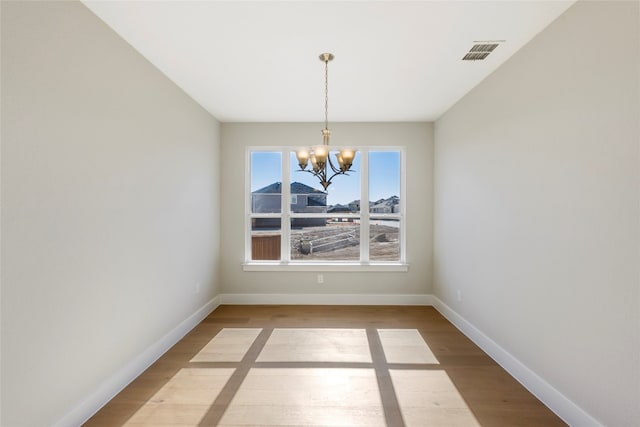 interior space with an inviting chandelier and hardwood / wood-style floors