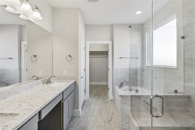 bathroom featuring tile floors, independent shower and bath, and double sink vanity