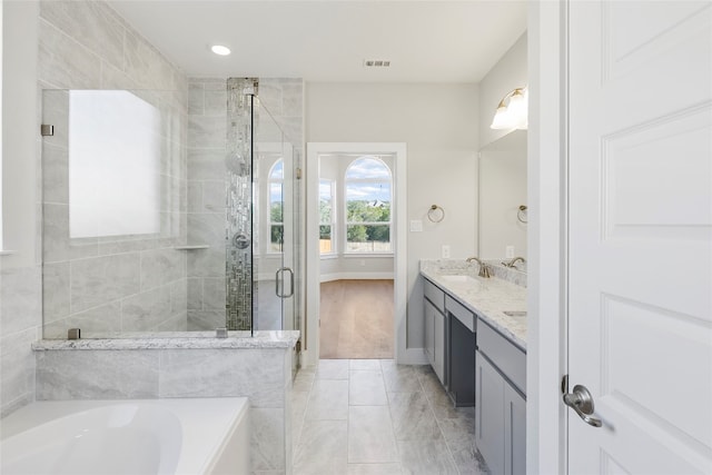 bathroom with tile floors, vanity with extensive cabinet space, and separate shower and tub