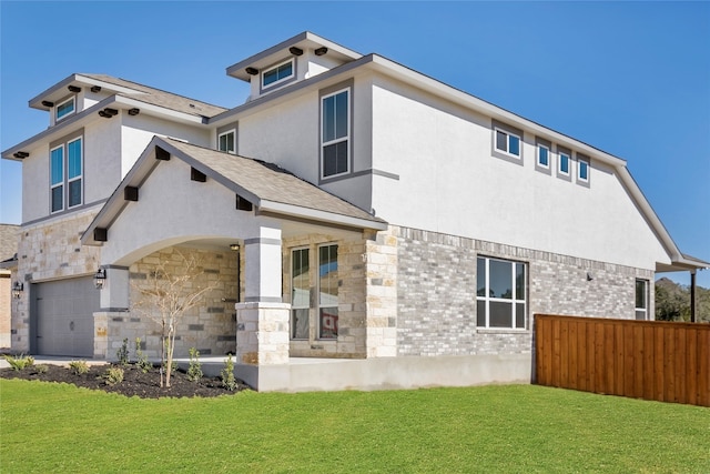 rear view of property featuring a garage and a lawn