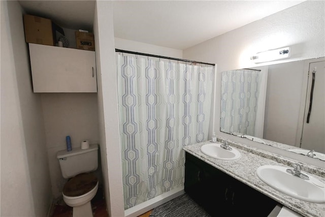 bathroom with oversized vanity, dual sinks, and toilet