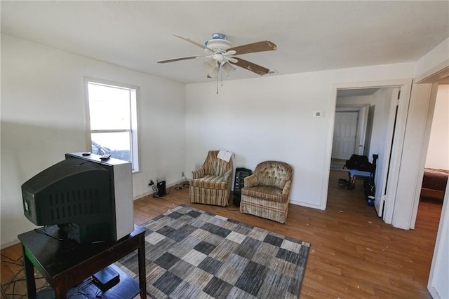 living room with dark wood-type flooring and ceiling fan