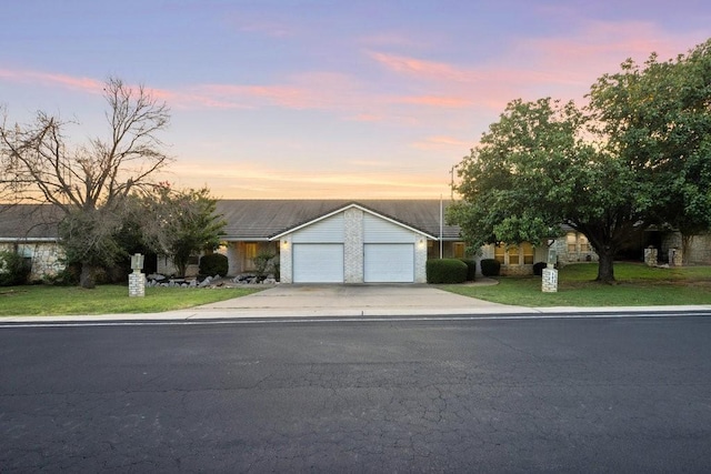 view of front of property featuring a garage, concrete driveway, and a front yard