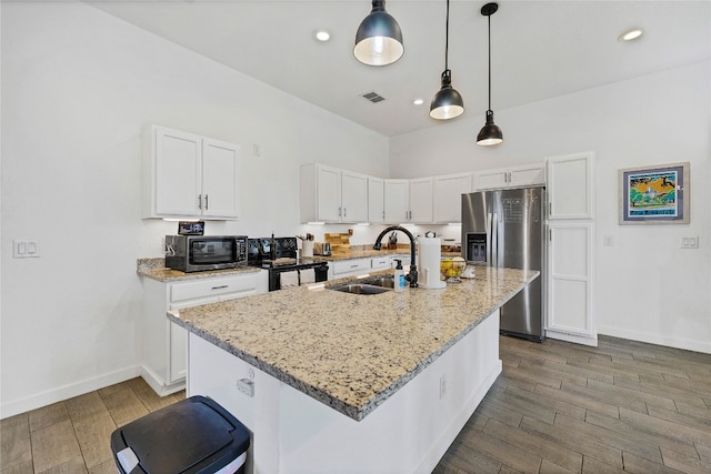 kitchen with light stone countertops, a center island with sink, white cabinets, and sink