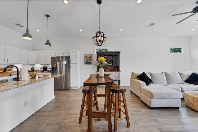 interior space featuring sink and ceiling fan with notable chandelier