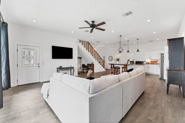 living room with light hardwood / wood-style floors and ceiling fan