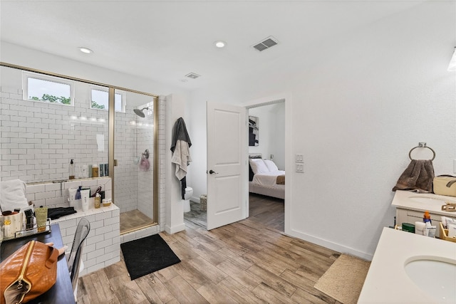 bathroom with a shower with door, vanity, toilet, and wood-type flooring