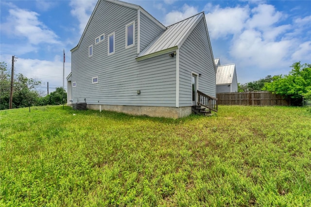 view of side of home featuring central AC and a yard