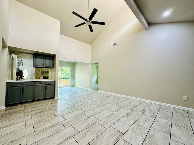 unfurnished living room featuring ceiling fan, light tile patterned floors, and high vaulted ceiling