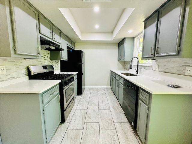 kitchen featuring backsplash, black appliances, sink, and a raised ceiling