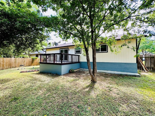 rear view of house with a yard and a wooden deck