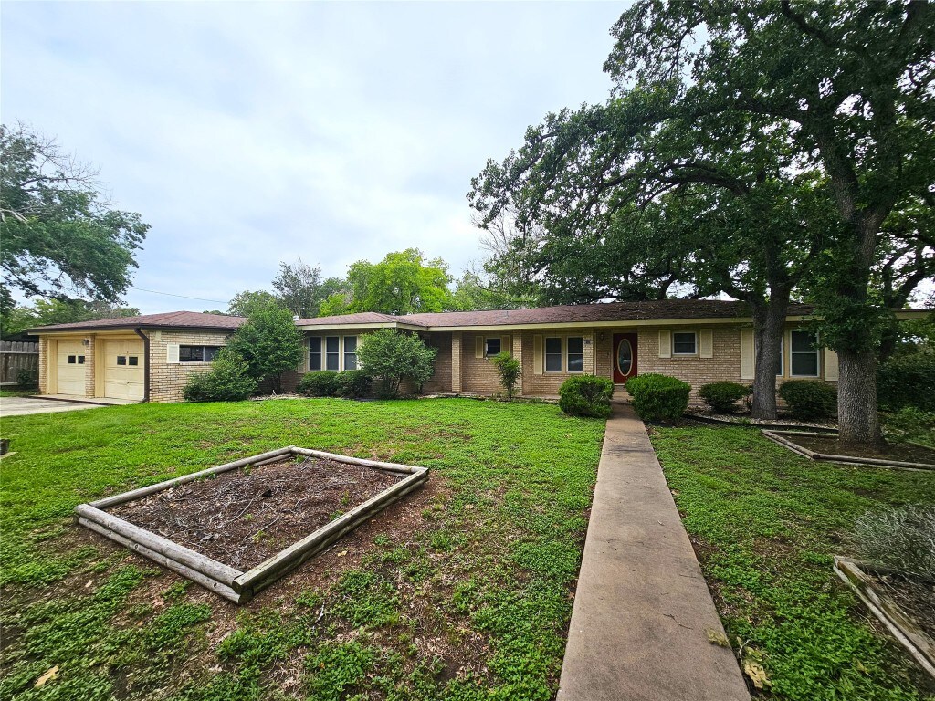 single story home featuring a front lawn and a garage